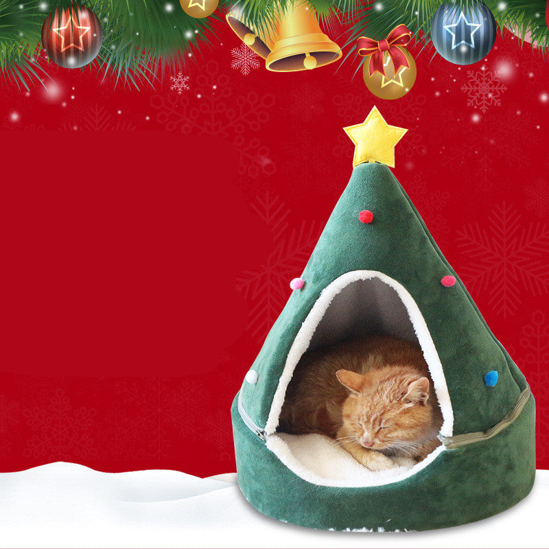 Green Christmas tree-shaped pet bed with a cat inside, decorated with festive ornaments on a red background.